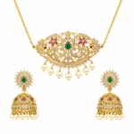 Gold-plated Indian jewelry set featuring a necklace and matching earrings. The necklace has an ornate filigree pendant with a central green emerald, pink gemstone accents, and dangling white faux pearls.