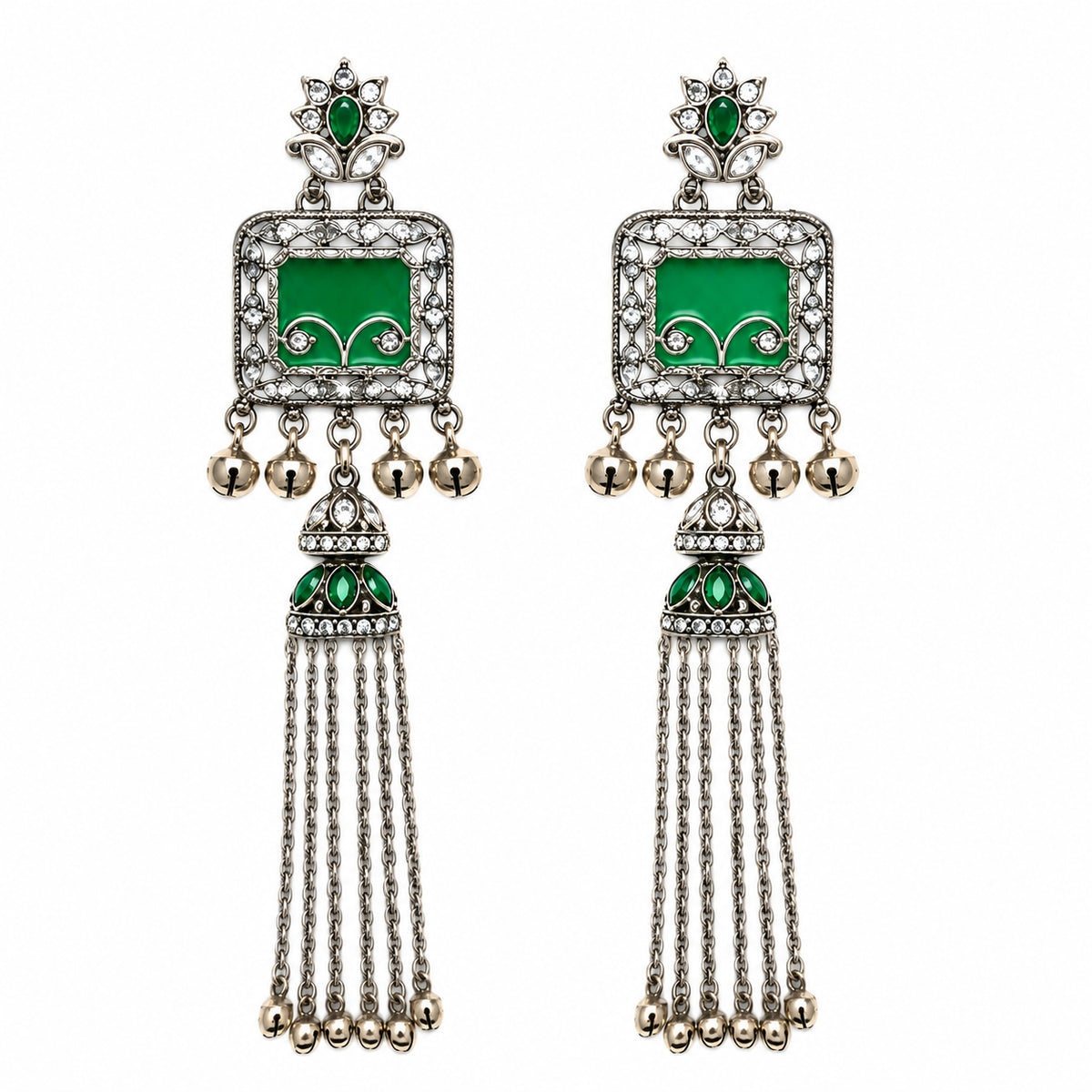 A pair of traditional Indian silver-toned dangle earrings with green enamel panels, clear pavé stones, and dangling gold-tone bells on a white background.