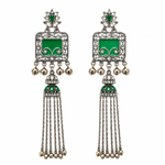 A pair of traditional Indian silver-toned dangle earrings with green enamel panels, clear pavé stones, and dangling gold-tone bells.