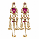 A pair of ornate gold-toned Indian jhumka earrings with vibrant magenta-pink enamel inlays and small red stones, shown on a plain white background.