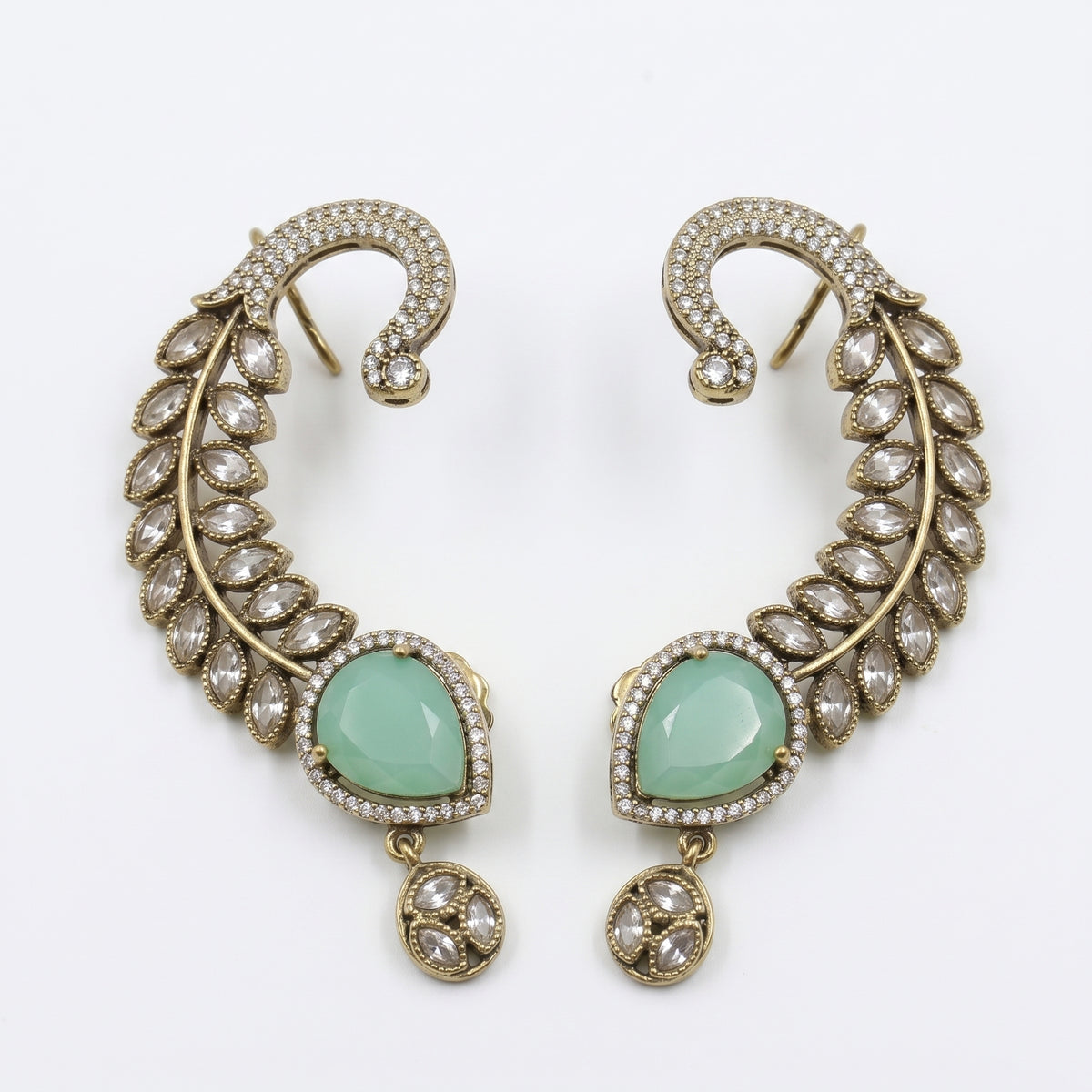 A pair of gold-toned crescent-shaped earrings with pavé-set clear stones and a central light green teardrop gemstone, shown on a plain white background.