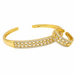 A gold-toned open cuff bracelet featuring two interlocking curved bands, both adorned with rows of small clear pavé stones. The clear stones are excluded from color mapping per the instructions, leaving the dominant color as Gold.