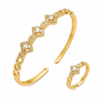Gold-tone open cuff bracelet and matching ring set with diamond-shaped pavé settings and clear central stones, shown on a clean white background.