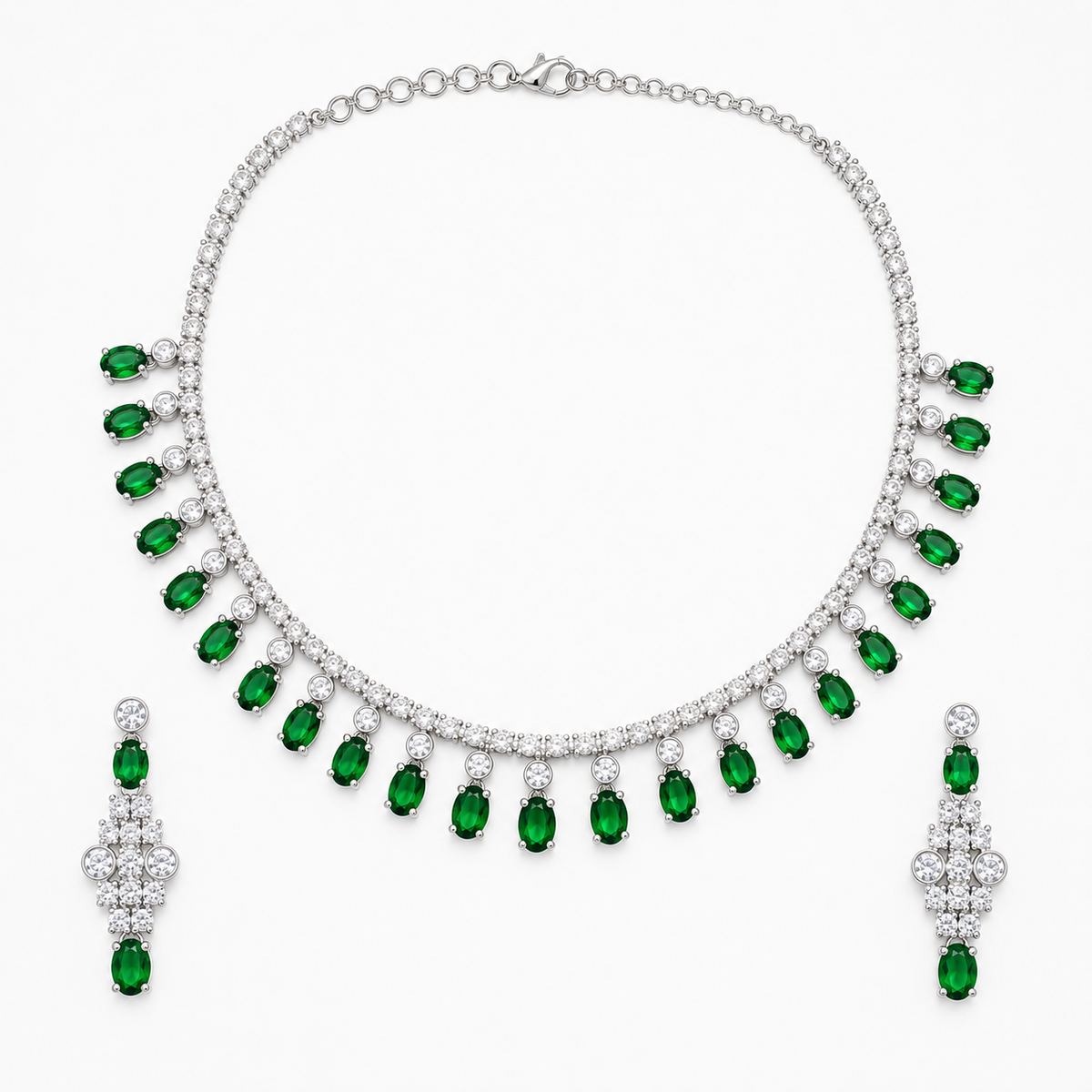 A silver-tone jewelry set featuring a collar necklace and matching drop earrings, both adorned with rows of clear stones and accented by oval-cut green emeralds, displayed on a clean white background.