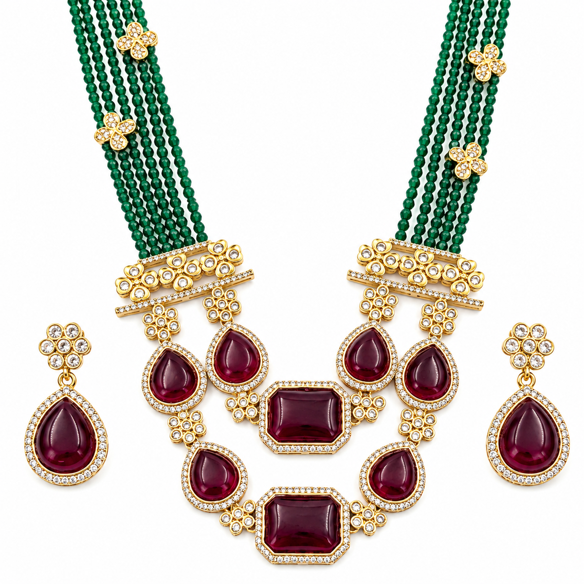 Gold-plated jewelry set featuring a multi-strand necklace with green beads and deep red teardrop gemstones, matching round and teardrop earrings, and intricate gold floral and diamond-like accents on a white background.