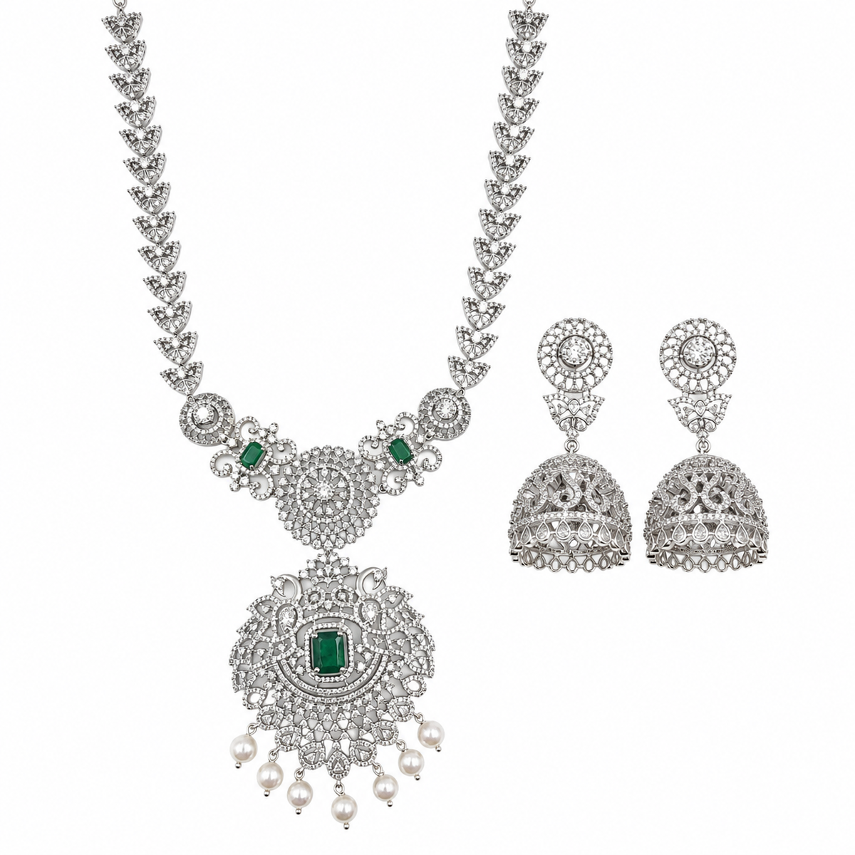 A silver-toned traditional Indian jewelry set featuring a necklace and matching earrings. The necklace has a detailed filigree chain and a large central pendant adorned with clear stones, a green rectangular emerald-cut stone, and small white pearl drops.
