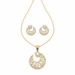 Gold crescent moon pendant necklace and matching stud earrings set, embellished with clear pavé gemstones on a white background.